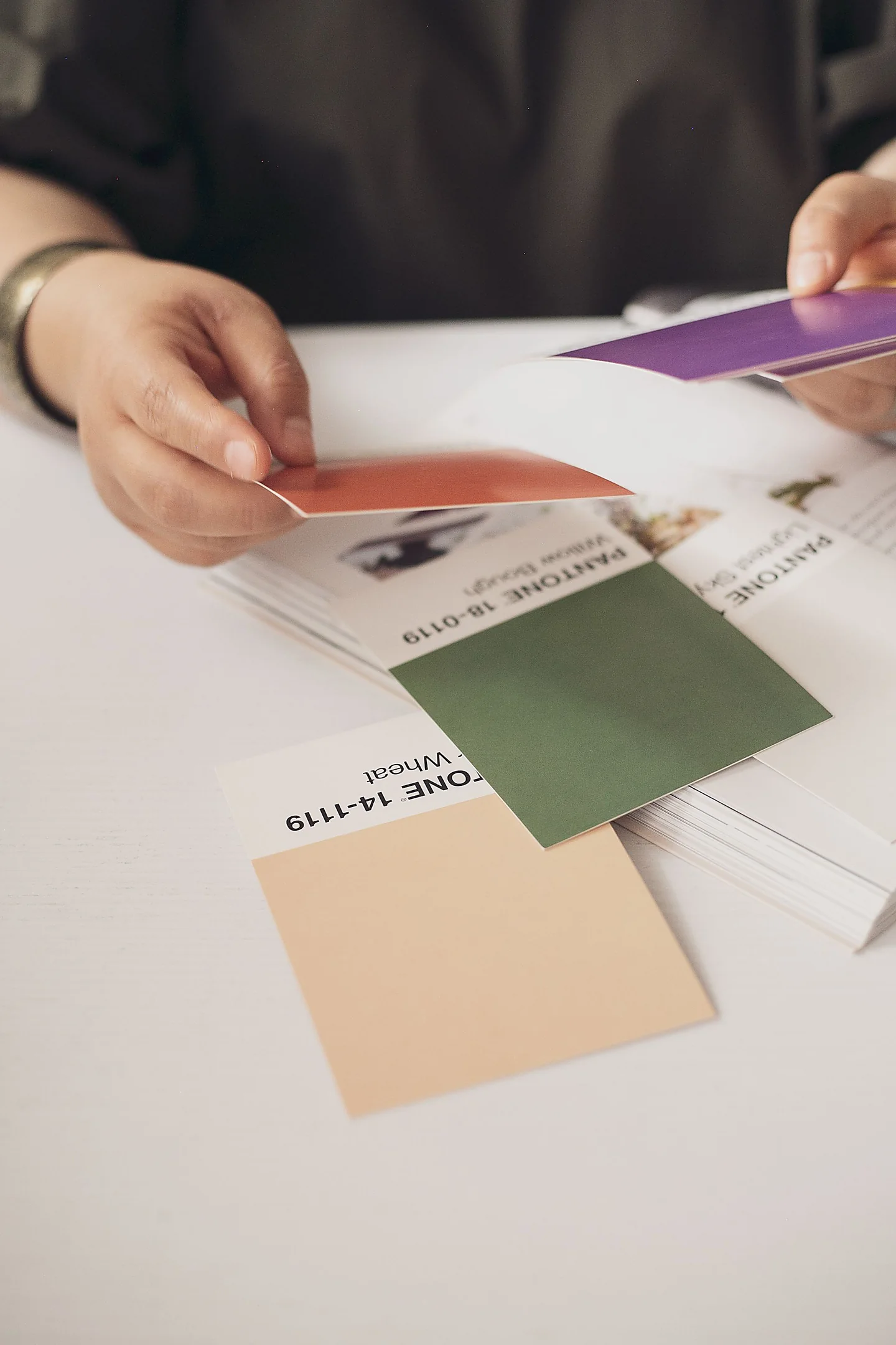 Mani che scelgono i campioni colore per un progetto grafico
